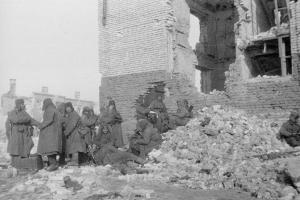 Солдаты одной из частей 64-й армии во время отдыха рядом с разрушенным зданием. Сталинград, зима 1943 года 
